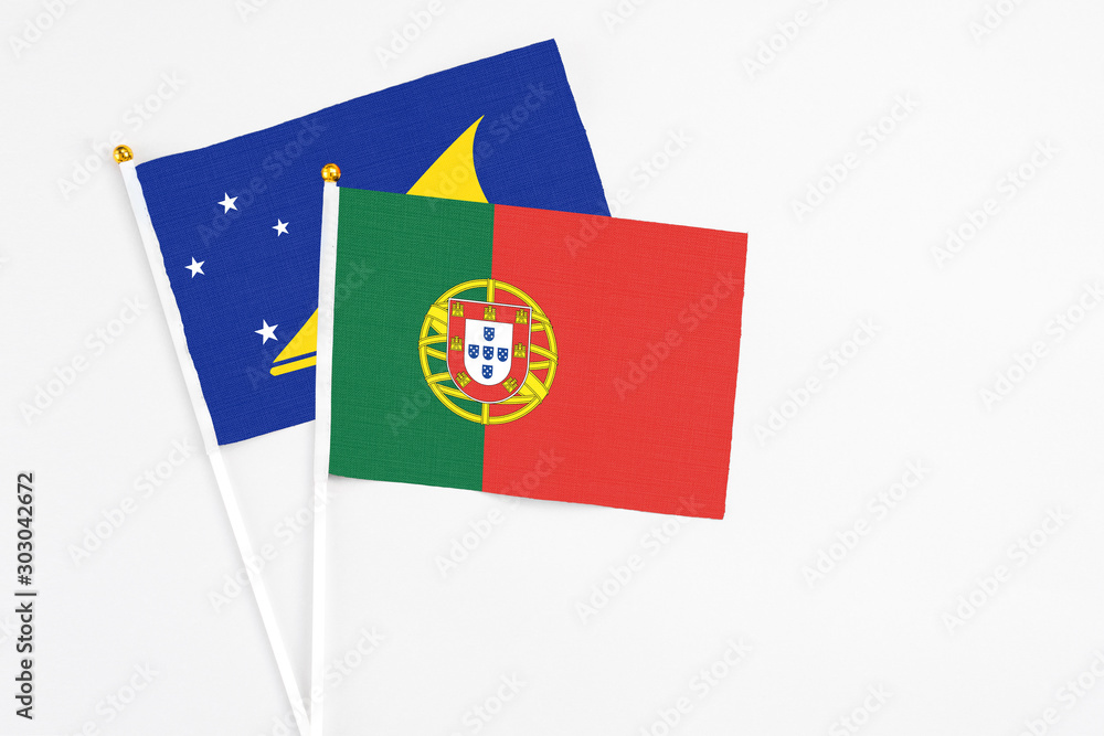 Portugal and Tokelau stick flags on white background. High quality fabric, miniature national flag. Peaceful global concept.White floor for copy space. Portugal and Tokelau stick flags on white background. High quality fabric, miniature national flag. Peaceful global concept.White floor for copy space.