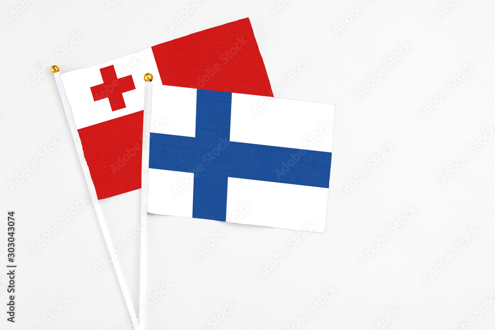 Finland and Tonga stick flags on white background. High quality fabric, miniature national flag. Peaceful global concept.White floor for copy space.