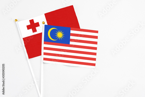 Malaysia and Tonga stick flags on white background. High quality fabric, miniature national flag. Peaceful global concept.White floor for copy space. photo