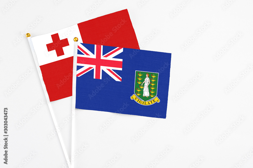 British Virgin Islands and Tonga stick flags on white background. High quality fabric, miniature national flag. Peaceful global concept.White floor for copy space.