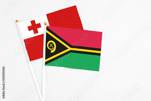 Vanuatu and Tonga stick flags on white background. High quality fabric, miniature national flag. Peaceful global concept.White floor for copy space. photo