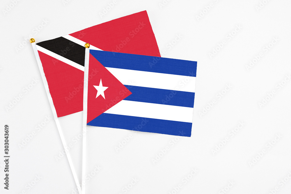 Cuba and Trinidad And Tobago stick flags on white background. High quality fabric, miniature national flag. Peaceful global concept.White floor for copy space.