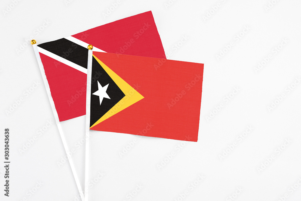 East Timor and Trinidad And Tobago stick flags on white background. High quality fabric, miniature national flag. Peaceful global concept.White floor for copy space. East Timor and Trinidad And Tobago stick flags on white background. High quality fabric, miniature national flag. Peaceful global concept.White floor for copy space.