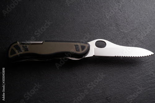 Multipurpose survivor tool knife on dark slate stone background photo