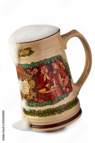 Large ceramic mug of beer with the monks depicted on it on white background
