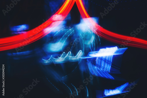 Abstract neon colour light motion over dark background. Slow shutter speed.