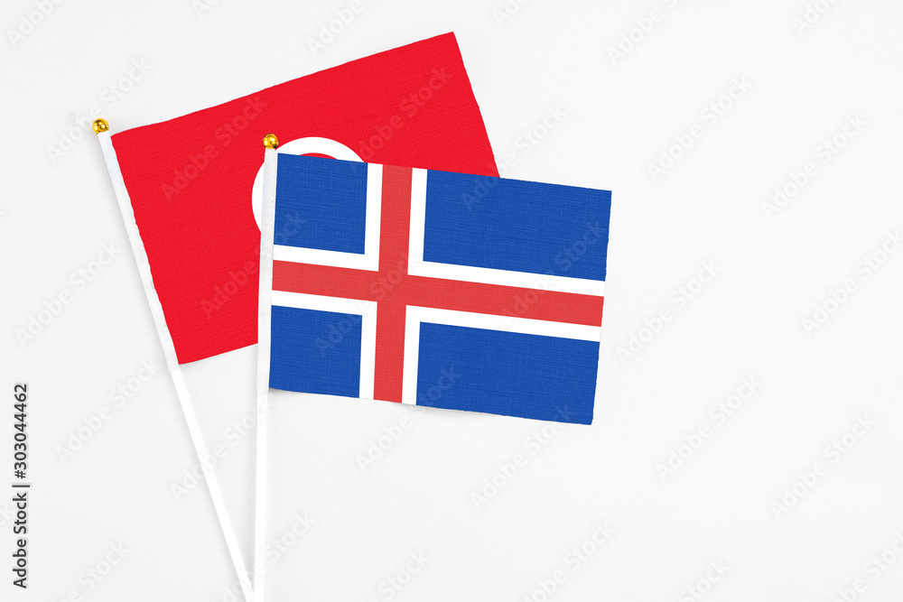 Iceland and Tunisia stick flags on white background. High quality fabric, miniature national flag. Peaceful global concept.White floor for copy space.