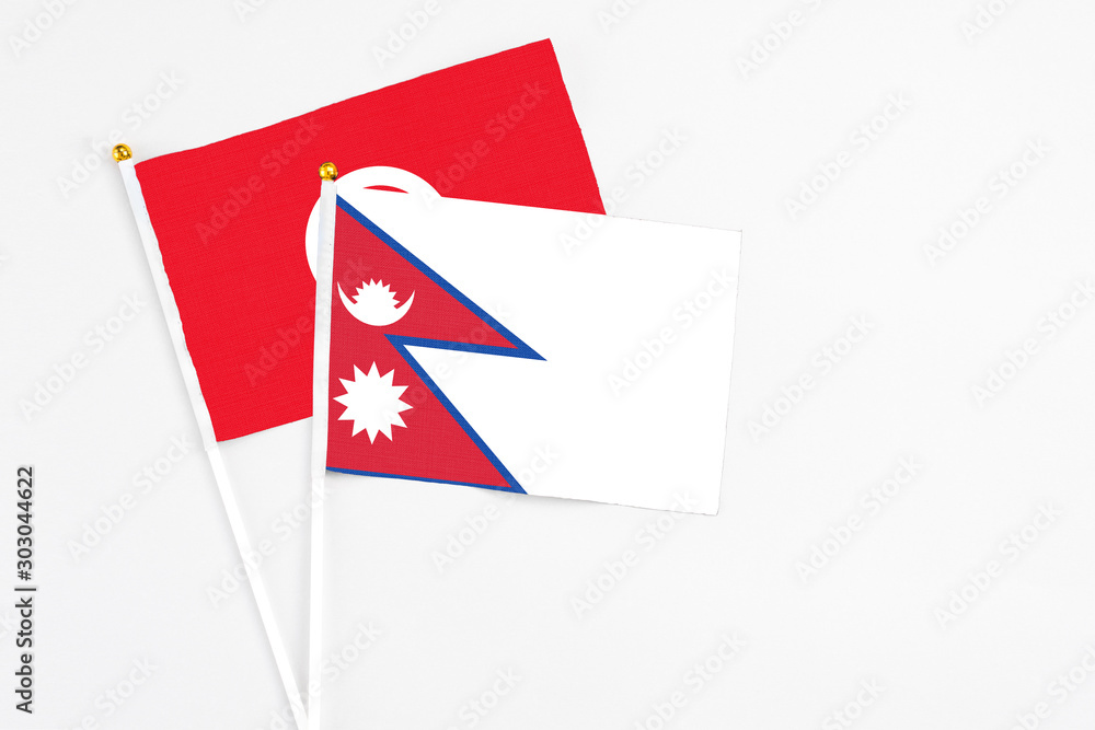 Obraz premium Nepal and Tunisia stick flags on white background. High quality fabric, miniature national flag. Peaceful global concept.White floor for copy space.
