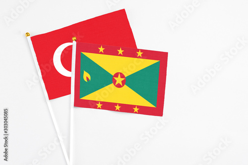 Grenada and Turkey stick flags on white background. High quality fabric, miniature national flag. Peaceful global concept.White floor for copy space.