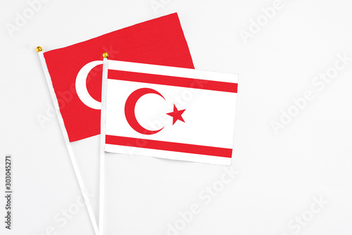 Northern Cyprus and Turkey stick flags on white background. High quality fabric, miniature national flag. Peaceful global concept.White floor for copy space.