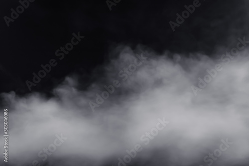Smoke dry ice move down nearly floor with massive size, have hard contrast on black background. Move spread around in the air