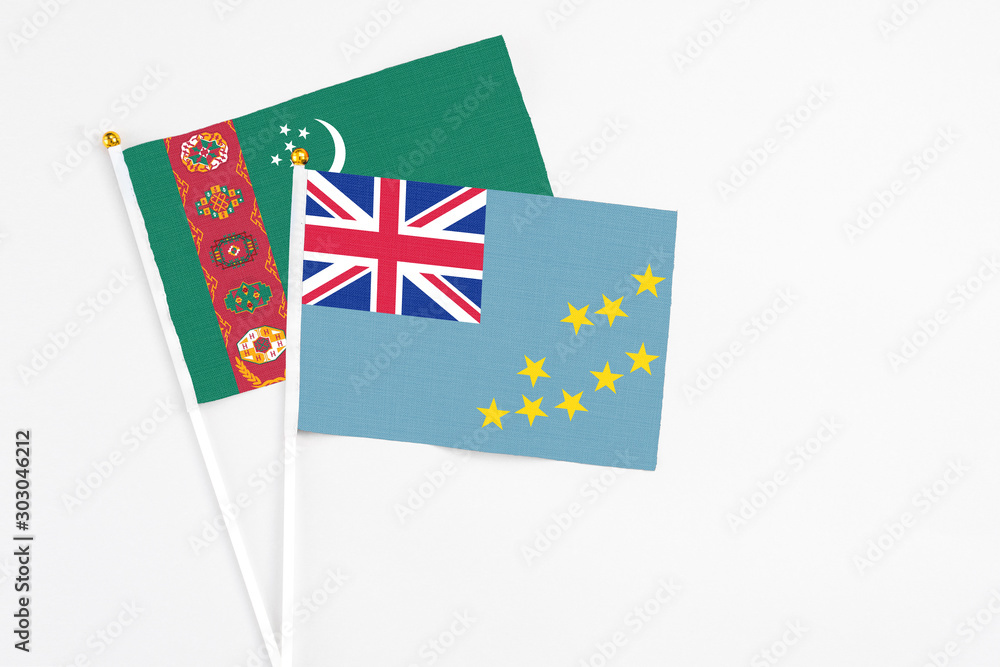 Tuvalu and Turkmenistan stick flags on white background. High quality fabric, miniature national flag. Peaceful global concept.White floor for copy space. Tuvalu and Turkmenistan stick flags on white background. High quality fabric, miniature national flag. Peaceful global concept.White floor for copy space.