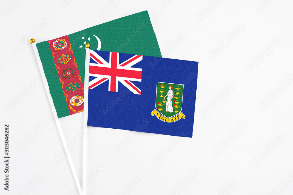 Fototapeta premium British Virgin Islands and Turkmenistan stick flags on white background. High quality fabric, miniature national flag. Peaceful global concept.White floor for copy space.
