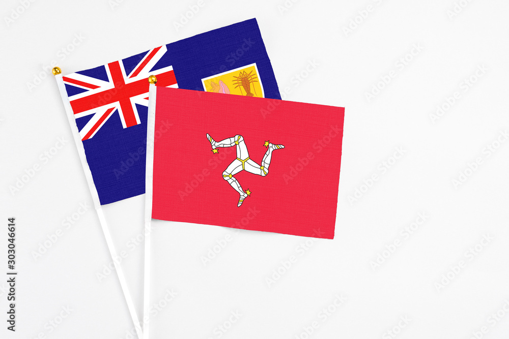 Fototapeta premium Isle Of Man and Turks And Caicos Islands stick flags on white background. High quality fabric, miniature national flag. Peaceful global concept.White floor for copy space.
