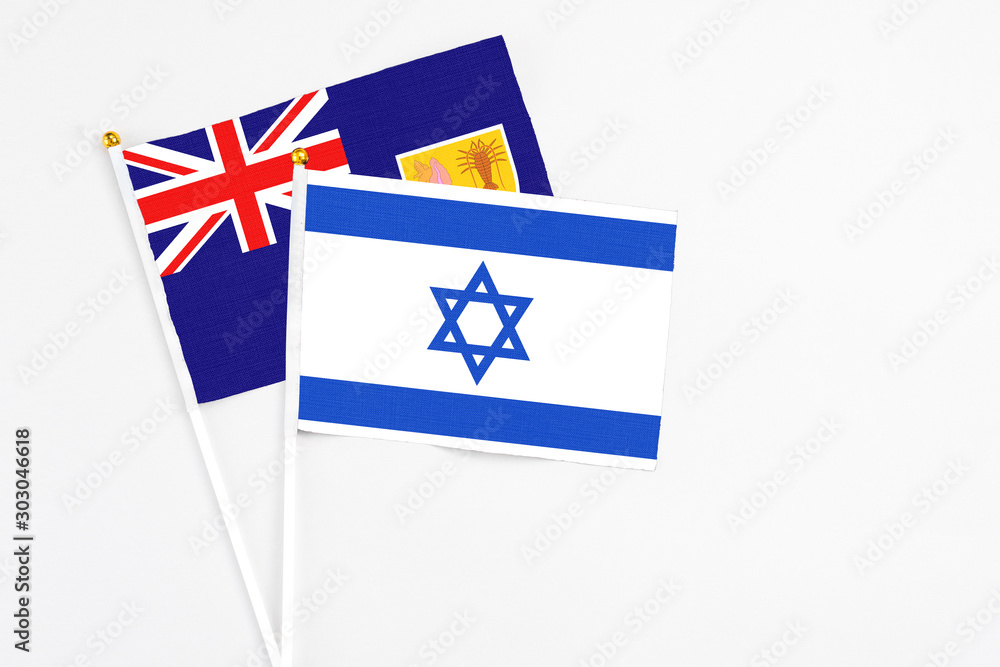 Fototapeta premium Israel and Turks And Caicos Islands stick flags on white background. High quality fabric, miniature national flag. Peaceful global concept.White floor for copy space.