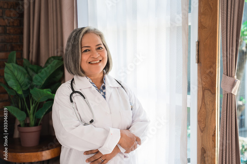 senior doctor with smiling when standing in front the windows