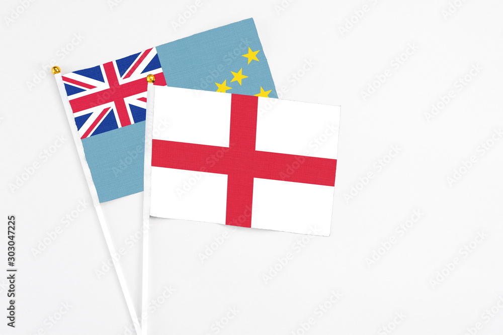 England and Tuvalu stick flags on white background. High quality fabric, miniature national flag. Peaceful global concept.White floor for copy space. England and Tuvalu stick flags on white background. High quality fabric, miniature national flag. Peaceful global concept.White floor for copy space.