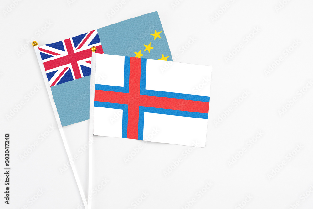 Faroe Islands and Tuvalu stick flags on white background. High quality fabric, miniature national flag. Peaceful global concept.White floor for copy space.