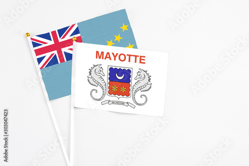 Mayotte and Tuvalu stick flags on white background. High quality fabric, miniature national flag. Peaceful global concept.White floor for copy space.