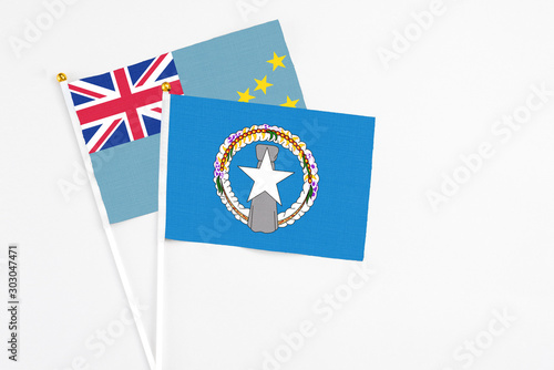 Northern Mariana Islands and Tuvalu stick flags on white background. High quality fabric, miniature national flag. Peaceful global concept.White floor for copy space.