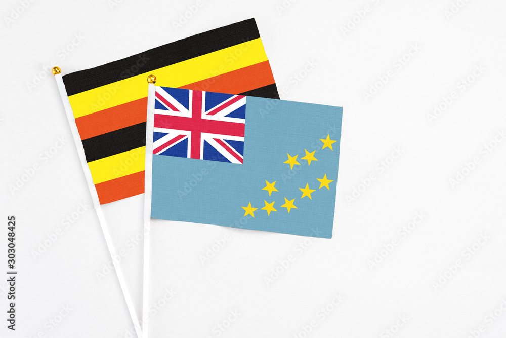 Tuvalu and Uganda stick flags on white background. High quality fabric, miniature national flag. Peaceful global concept.White floor for copy space. Tuvalu and Uganda stick flags on white background. High quality fabric, miniature national flag. Peaceful global concept.White floor for copy space.