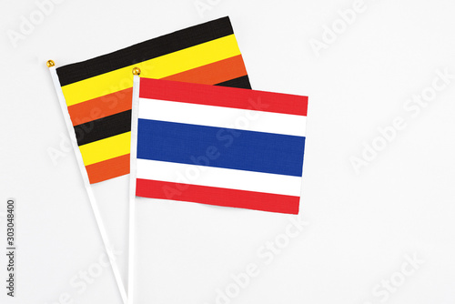 Free Download Thailand and Uganda stick flags on white background. High quality fabric, miniature national flag. Peaceful global concept.White floor for copy space. - GFXLoad