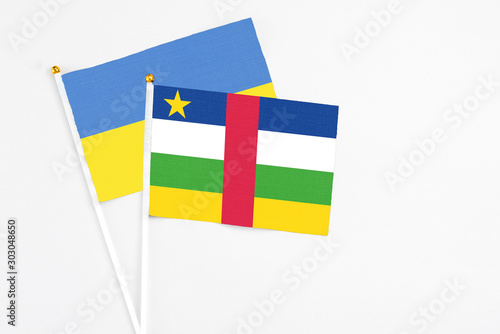 Central African Republic and Ukraine stick flags on white background. High quality fabric, miniature national flag. Peaceful global concept.White floor for copy space. photo