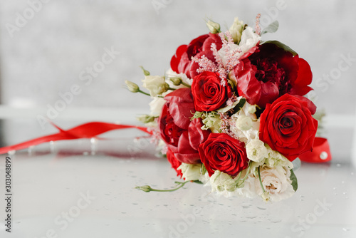 wedding bouquet of red and white flowers on a glass table
