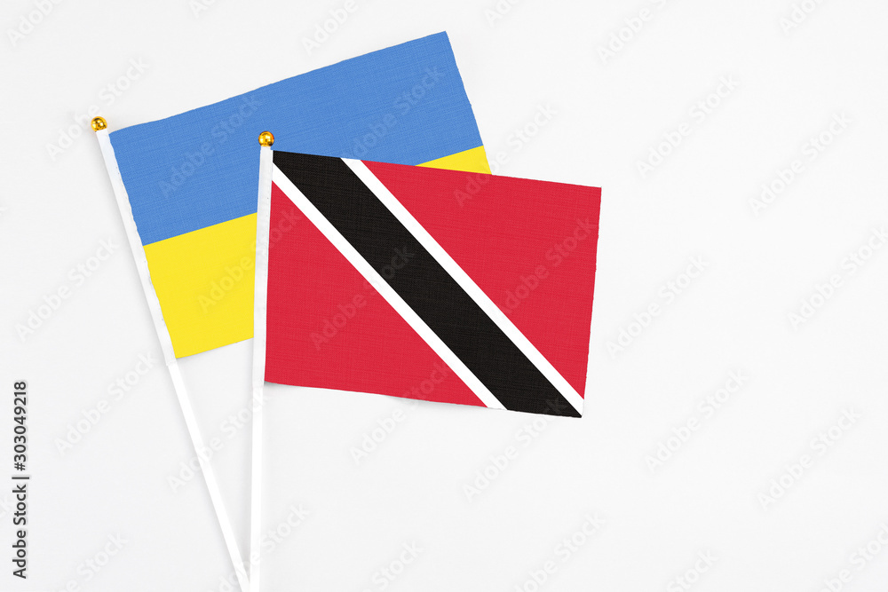Trinidad And Tobago and Ukraine stick flags on white background. High quality fabric, miniature national flag. Peaceful global concept.White floor for copy space. Trinidad And Tobago and Ukraine stick flags on white background. High quality fabric, miniature national flag. Peaceful global concept.White floor for copy space.