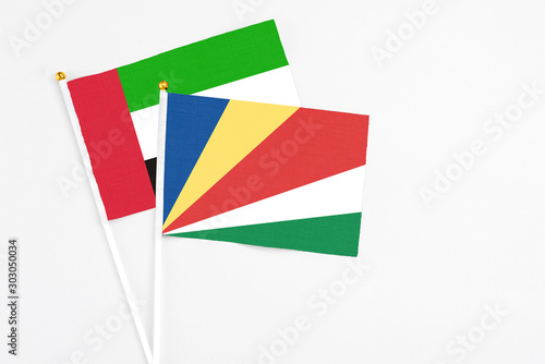 Seychelles and United Arab Emirates stick flags on white background. High quality fabric  miniature national flag. Peaceful global concept.White floor for copy space.
