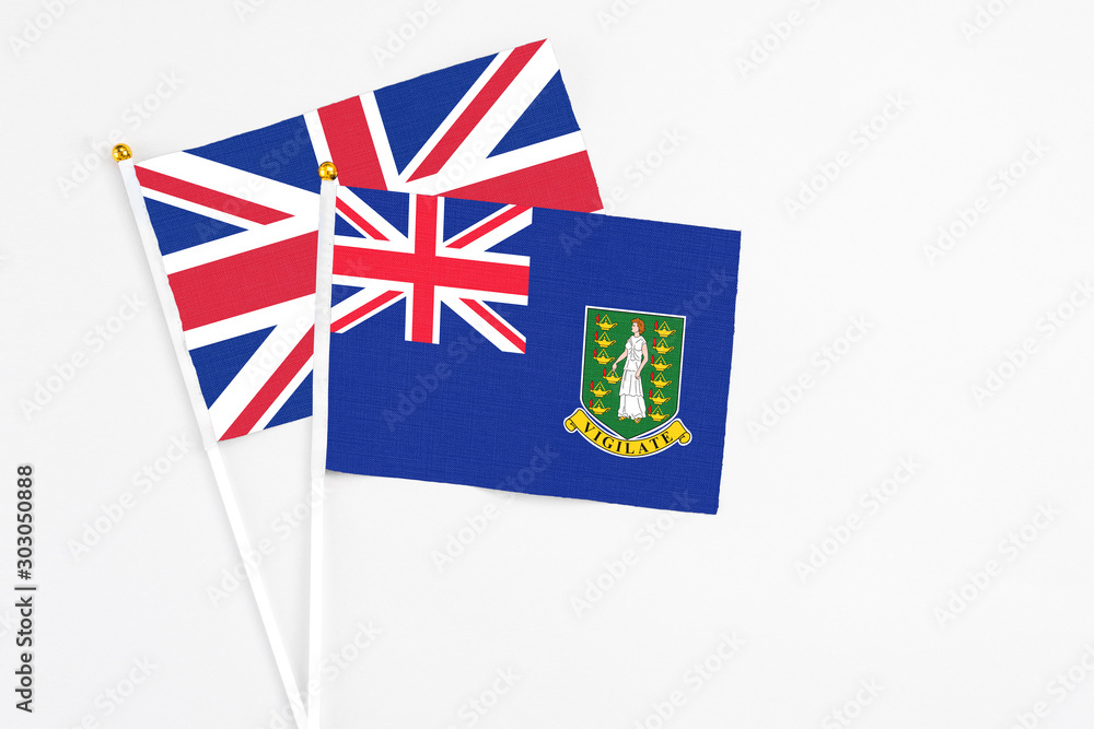 Fototapeta premium British Virgin Islands and United Kingdom stick flags on white background. High quality fabric, miniature national flag. Peaceful global concept.White floor for copy space.