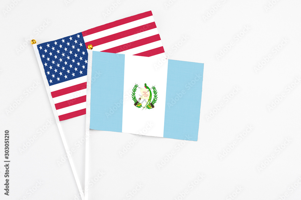 Guatemala and United States stick flags on white background. High quality fabric, miniature national flag. Peaceful global concept.White floor for copy space. Guatemala and United States stick flags on white background. High quality fabric, miniature national flag. Peaceful global concept.White floor for copy space.