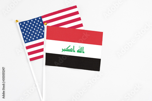 Iraq and United States stick flags on white background. High quality fabric, miniature national flag. Peaceful global concept.White floor for copy space. photo