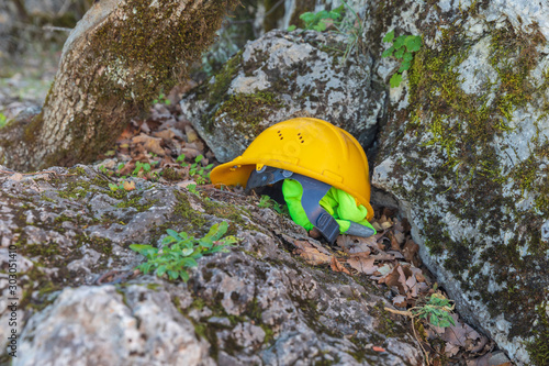 Yellow work helmet lying on a stone