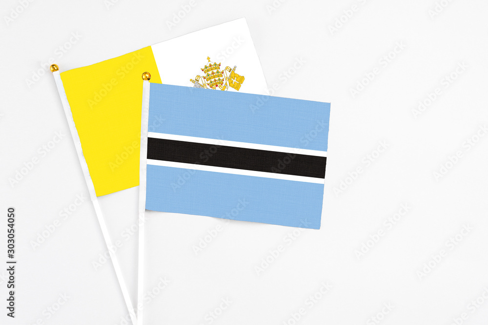 Botswana and Vatican City stick flags on white background. High quality fabric, miniature national flag. Peaceful global concept.White floor for copy space. Botswana and Vatican City stick flags on white background. High quality fabric, miniature national flag. Peaceful global concept.White floor for copy space.