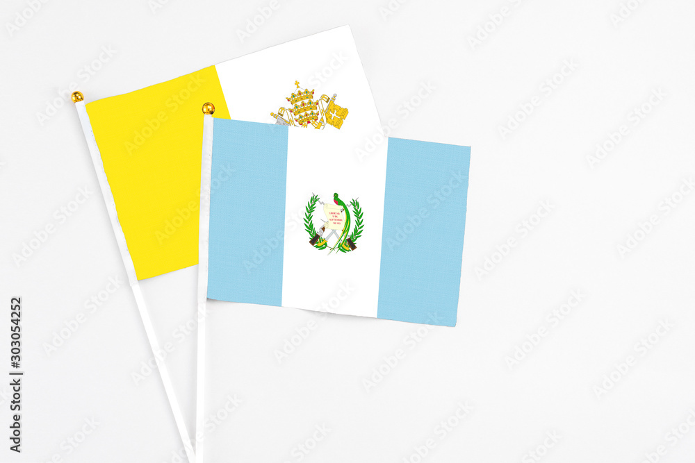 Guatemala and Vatican City stick flags on white background. High quality fabric, miniature national flag. Peaceful global concept.White floor for copy space. Guatemala and Vatican City stick flags on white background. High quality fabric, miniature national flag. Peaceful global concept.White floor for copy space.