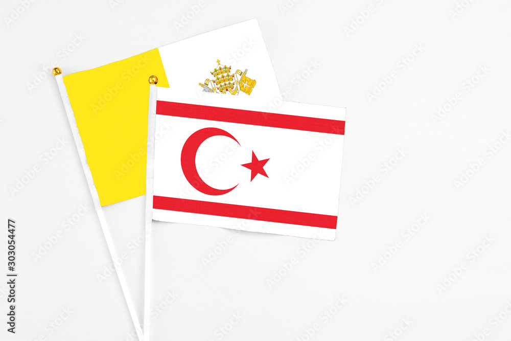 Northern Cyprus and Vatican City stick flags on white background. High quality fabric, miniature national flag. Peaceful global concept.White floor for copy space.