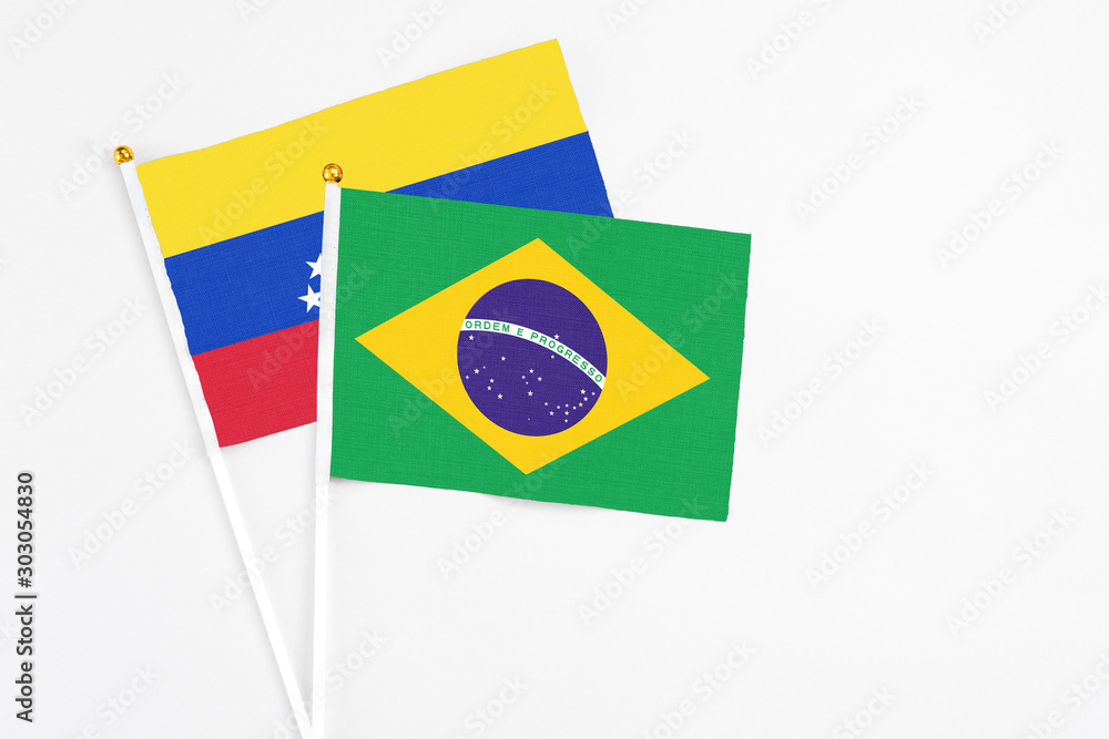 Brazil and Venezuela stick flags on white background. High quality fabric, miniature national flag. Peaceful global concept.White floor for copy space.