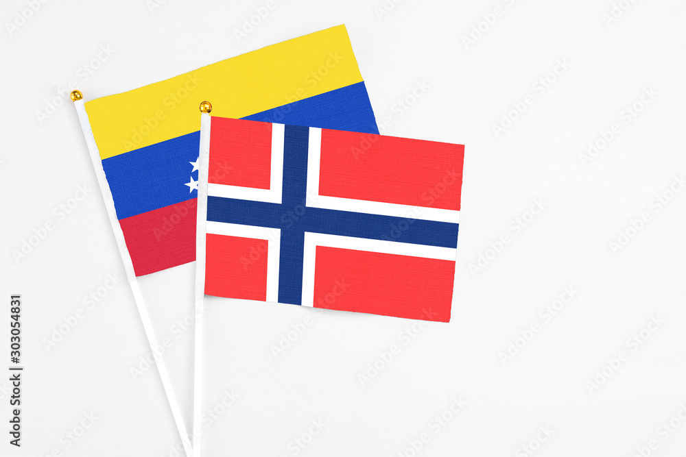 Bouvet Islands and Venezuela stick flags on white background. High quality fabric, miniature national flag. Peaceful global concept.White floor for copy space.