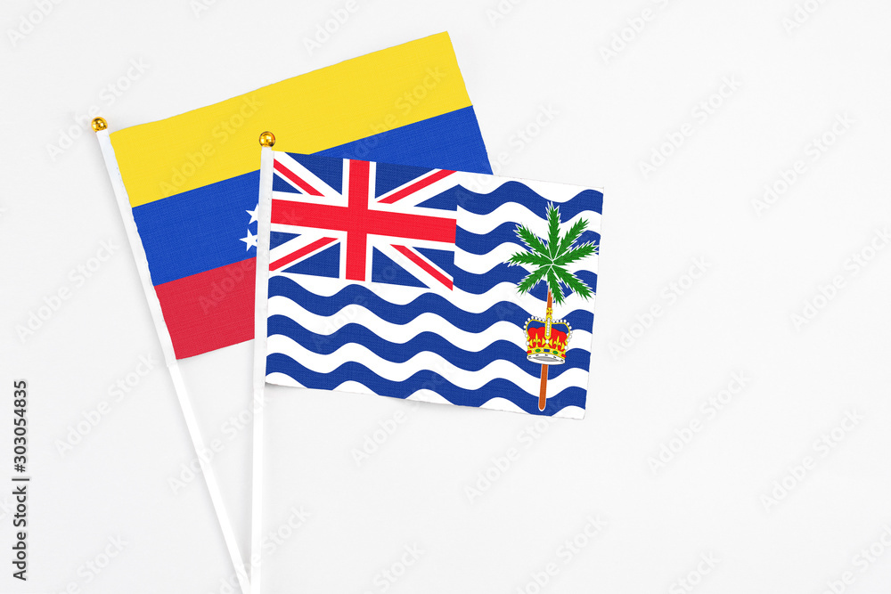 Fototapeta premium British Indian Ocean Territory and Venezuela stick flags on white background. High quality fabric, miniature national flag. Peaceful global concept.White floor for copy space.