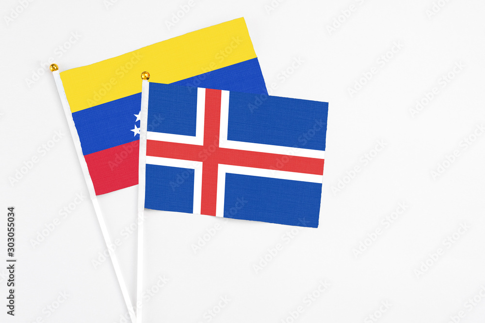 Iceland and Venezuela stick flags on white background. High quality fabric, miniature national flag. Peaceful global concept.White floor for copy space.