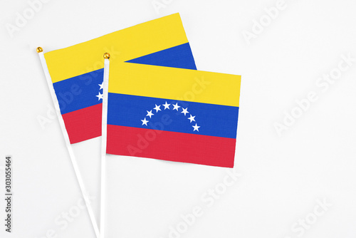Venezuela and Venezuela stick flags on white background. High quality fabric  miniature national flag. Peaceful global concept.White floor for copy space.