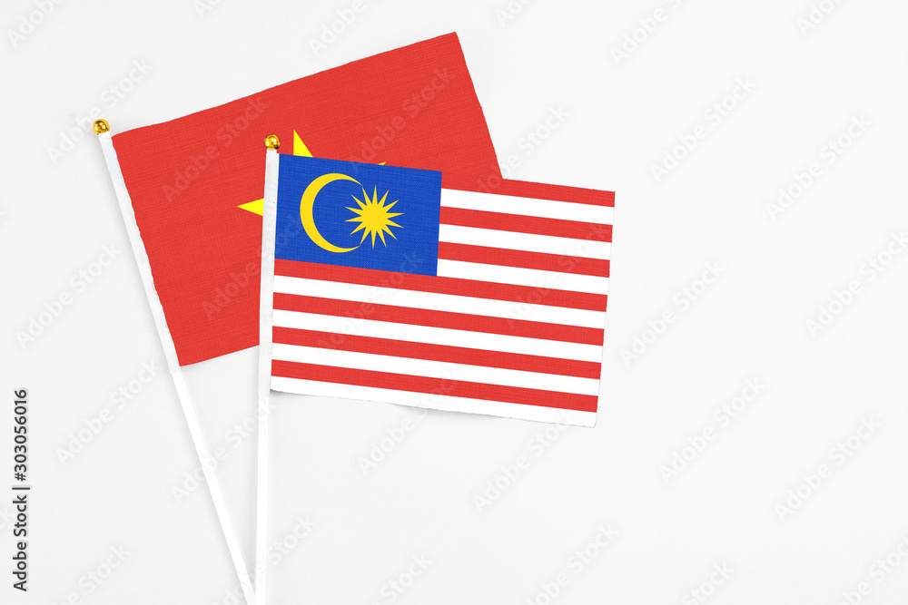Malaysia and Vietnam stick flags on white background. High quality fabric, miniature national flag. Peaceful global concept.White floor for copy space. Malaysia and Vietnam stick flags on white background. High quality fabric, miniature national flag. Peaceful global concept.White floor for copy space.
