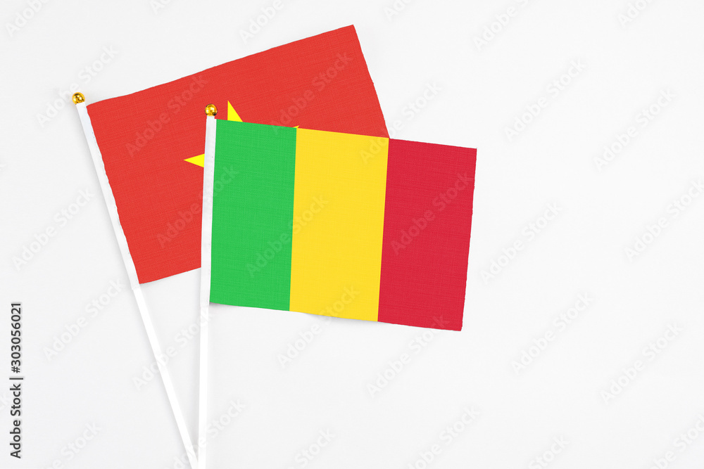 Mali and Vietnam stick flags on white background. High quality fabric, miniature national flag. Peaceful global concept.White floor for copy space. Mali and Vietnam stick flags on white background. High quality fabric, miniature national flag. Peaceful global concept.White floor for copy space.