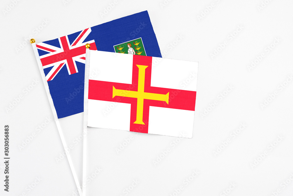 Guernsey and British Virgin Islands stick flags on white background. High quality fabric, miniature national flag. Peaceful global concept.White floor for copy space.