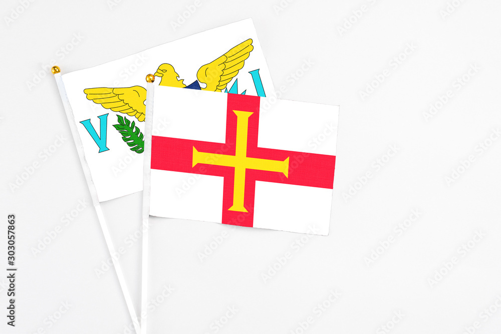 Guernsey and United States Virgin Islands stick flags on white background. High quality fabric, miniature national flag. Peaceful global concept.White floor for copy space.