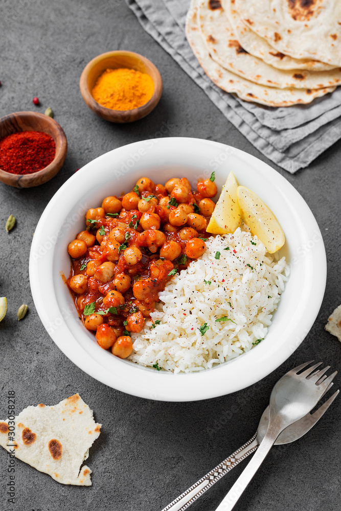 Traditional Indian dish chickpea chana masala with rice and flatbread ...