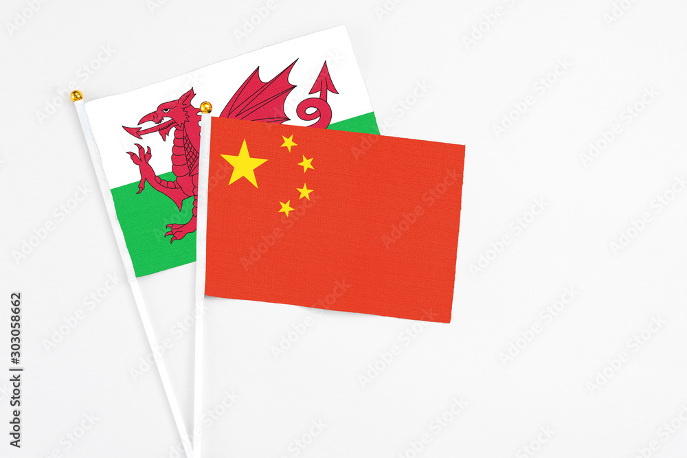China and Wales stick flags on white background. High quality fabric, miniature national flag. Peaceful global concept.White floor for copy space. China and Wales stick flags on white background. High quality fabric, miniature national flag. Peaceful global concept.White floor for copy space.