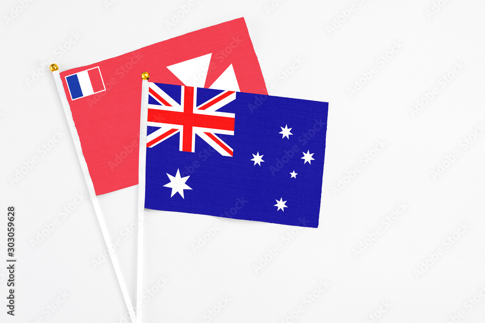 Fototapeta premium Australia and Wallis And Futuna stick flags on white background. High quality fabric, miniature national flag. Peaceful global concept.White floor for copy space.