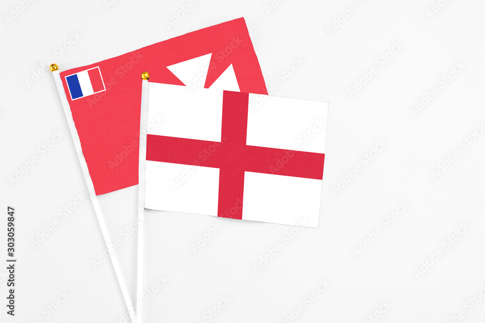 England and Wallis And Futuna stick flags on white background. High quality fabric, miniature national flag. Peaceful global concept.White floor for copy space.